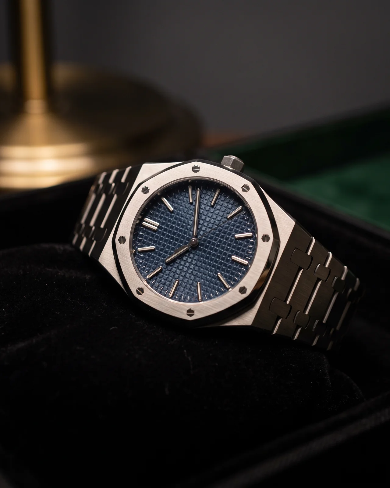 The octagonal bezel and first links of a steel Royal Oak under raking light, polished bevels bright against the brushed surfaces.
