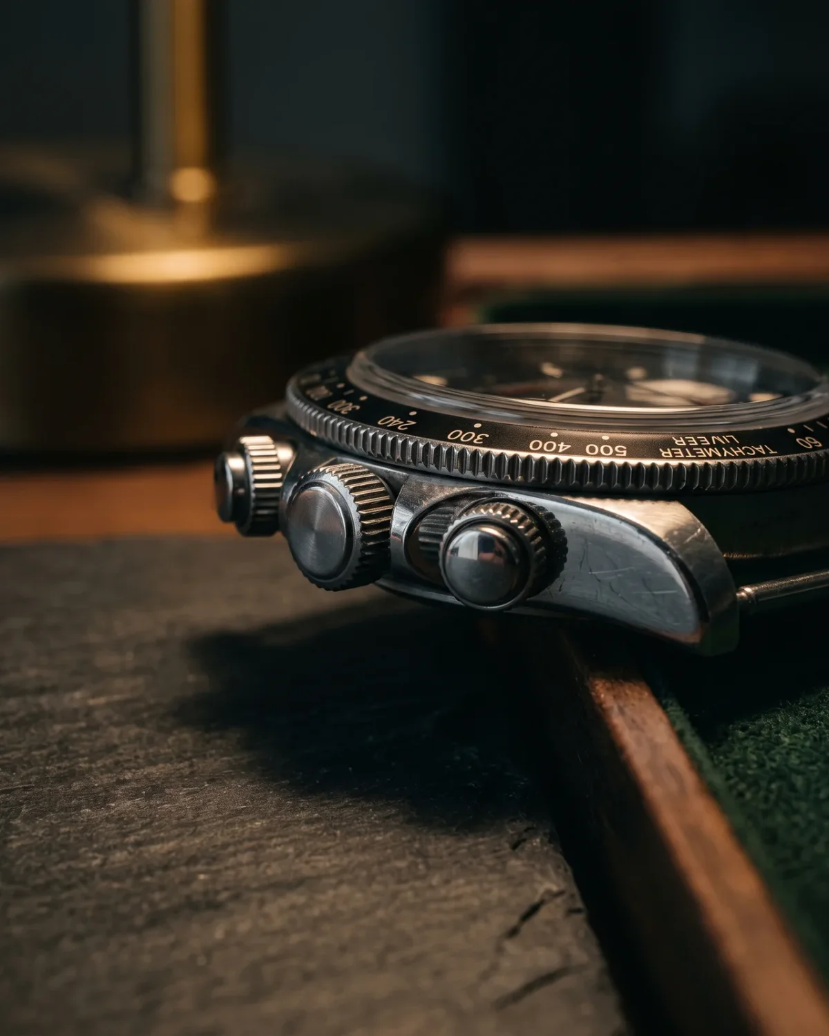 A Breitling Rouleaux bracelet laid flat with the clasp open, the roller links catching light, beside a Chronomat caseback showing its reference.