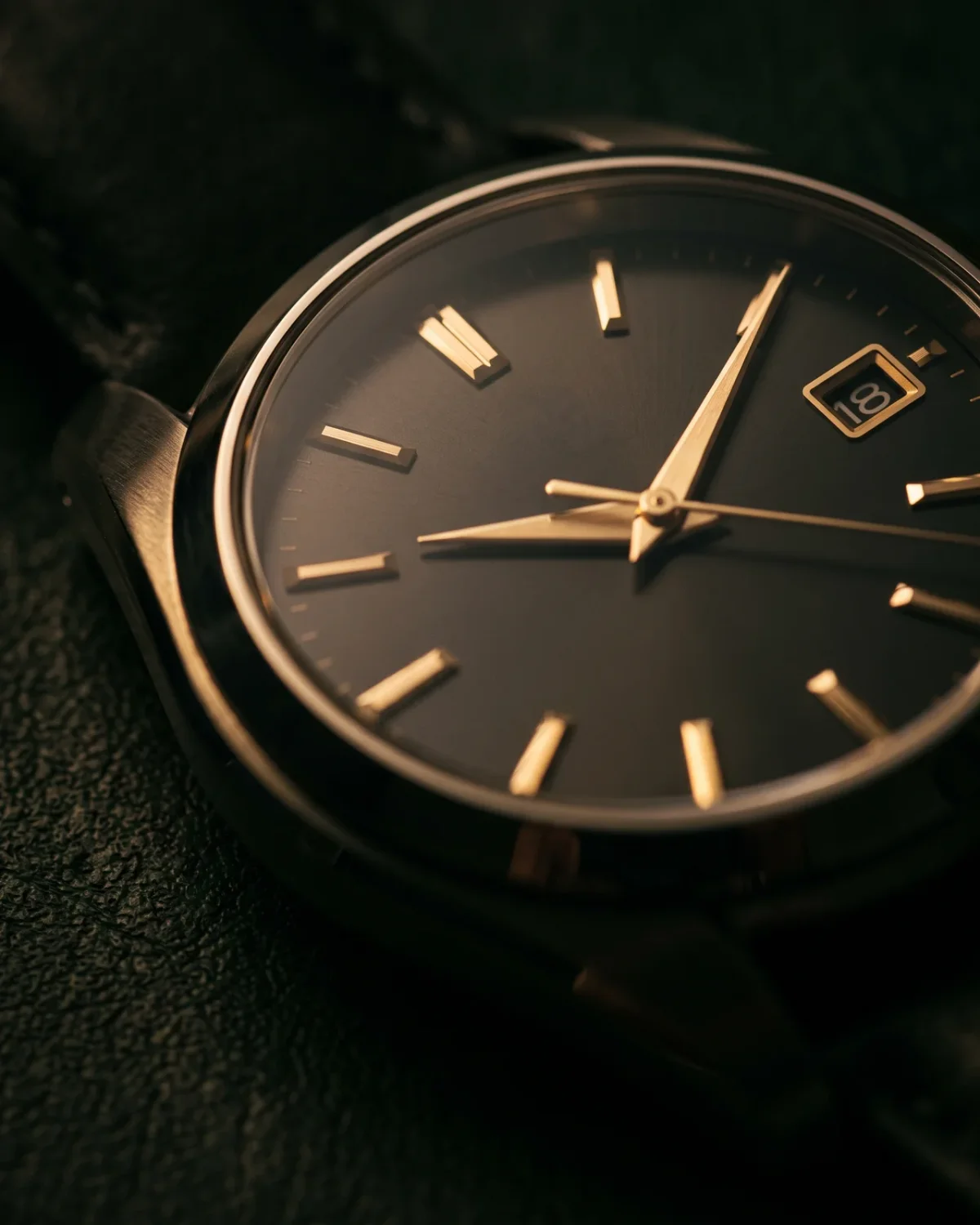 A steel bracelet with rounded, polished links laid flat beside a folded leather strap, the choice a Breitling buyer makes.