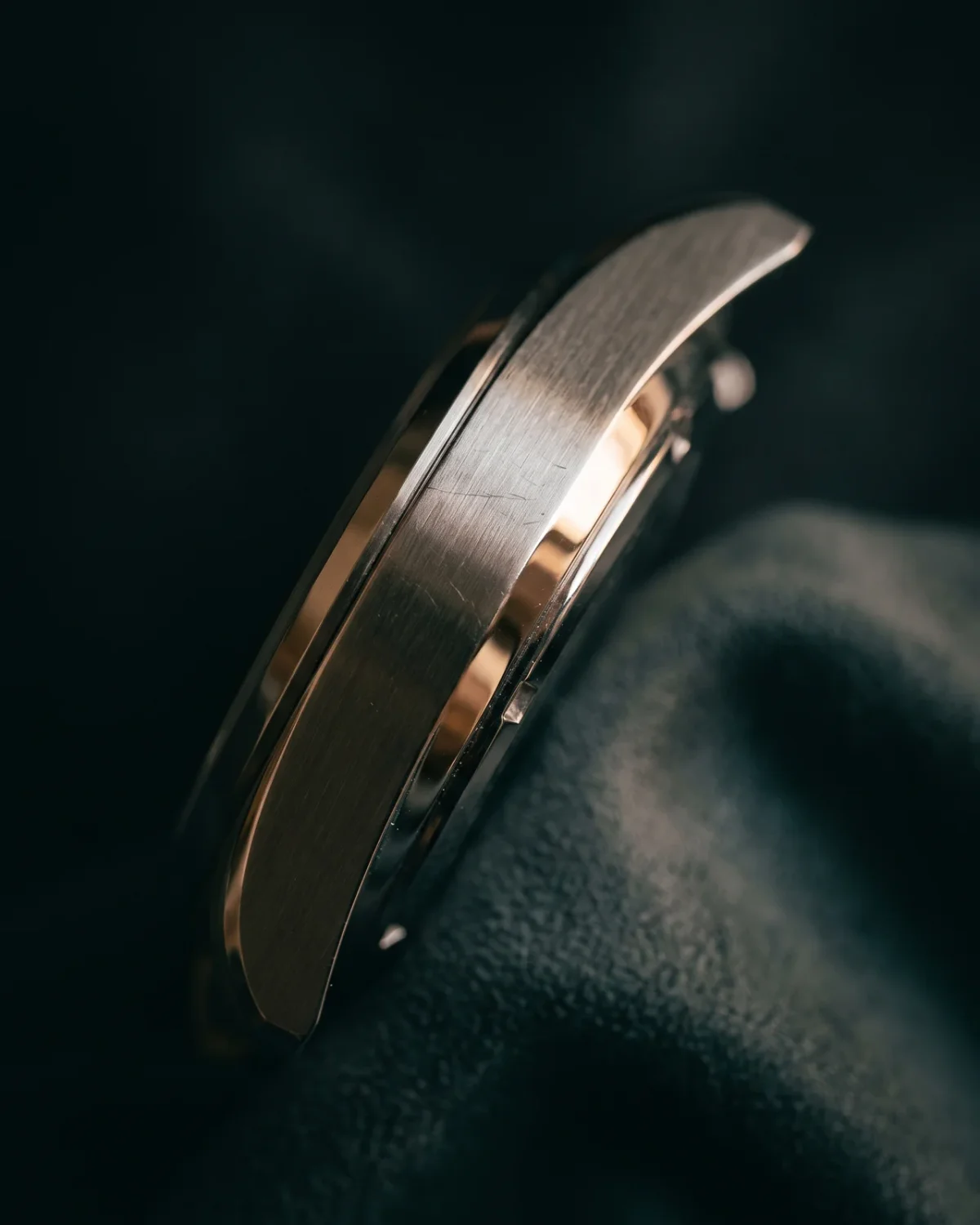 A steel bracelet watch resting on a folded microfibre cloth, the only cleaning tool a seller should use.