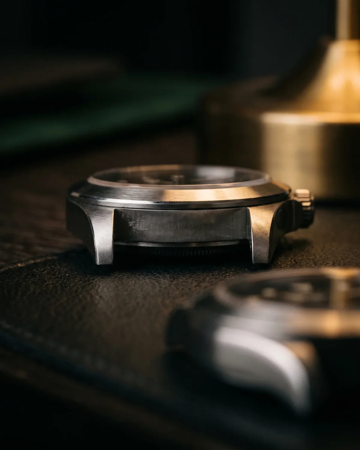 A Rolex warranty card and hang tag beside a closed green box, showing what a complete pre-owned set looks like.