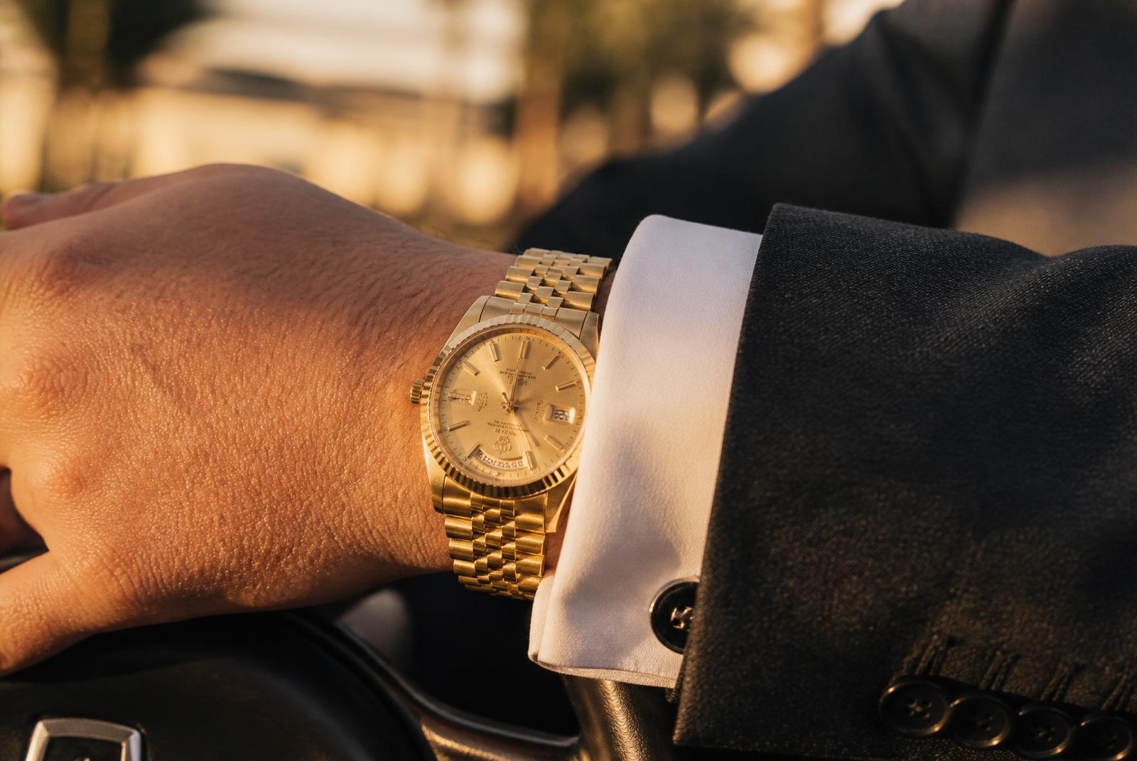 Gold Rolex Day-Date worn with a French-cuff shirt in Miami golden hour